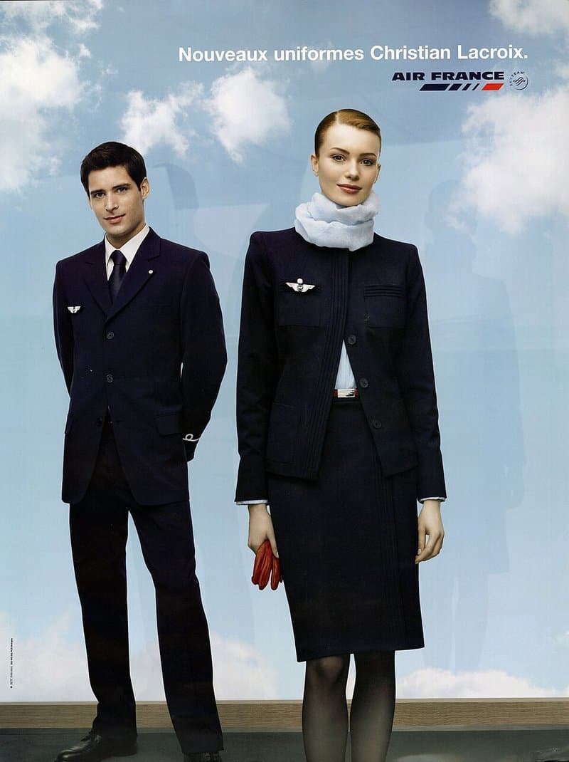 Cartel de Air France que anuncia los nuevos uniformes de Christian Lacroix, un auxiliar y una azafata de azul marino