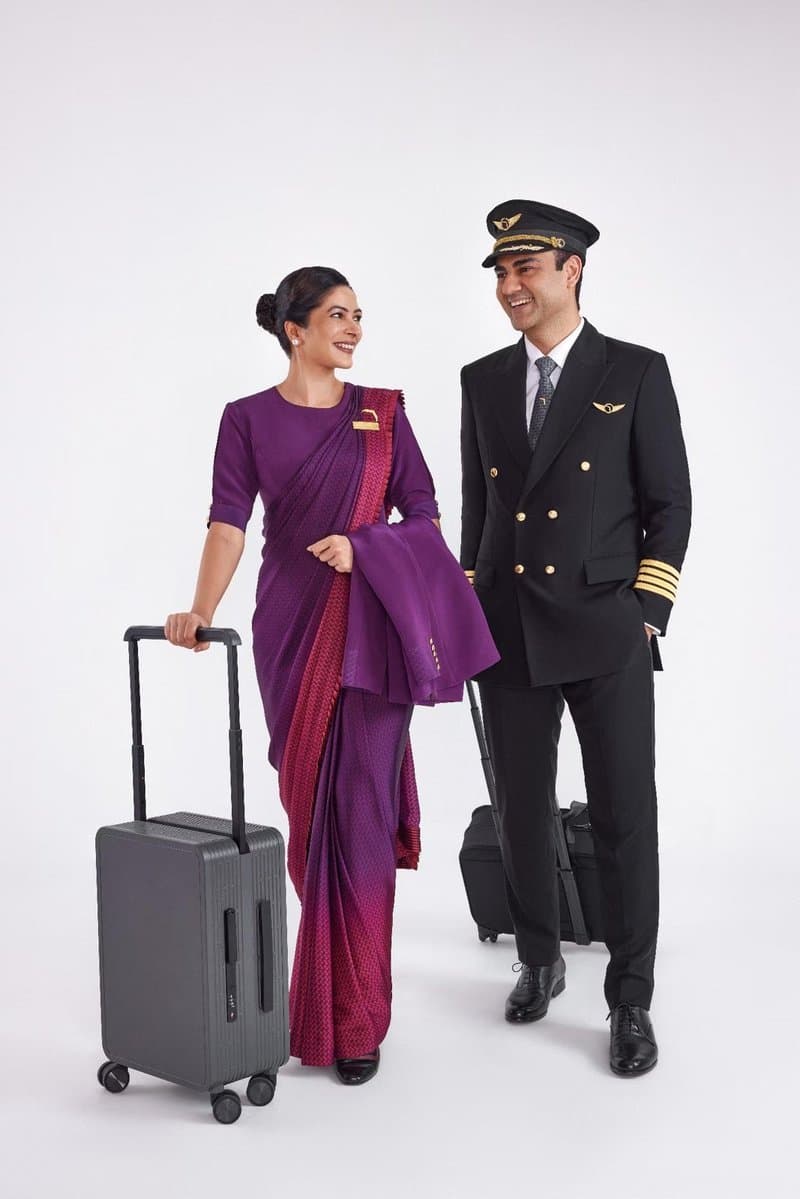 Tripulación de Air India con el vestuario de Manish Malhotra de 2023, sari violeta junto a una chaqueta negra de piloto con galones dorados