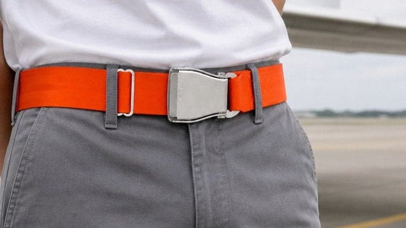 Ceinture d'avion TROPIC orange signal portée avec un pantalon gris sur le tarmac