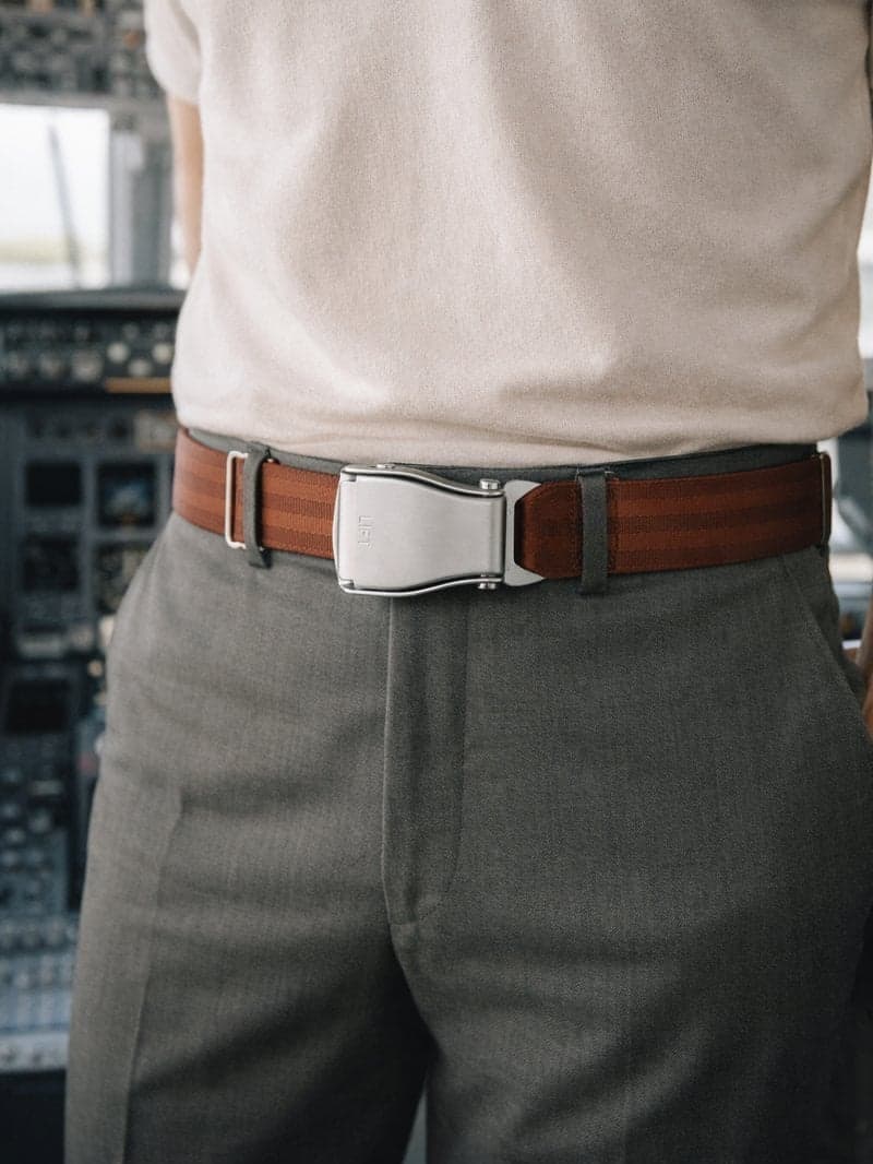 Ceinture d'avion SILK ROAD marron chaud portée avec un pantalon vert olive et un haut crème, dans un cockpit