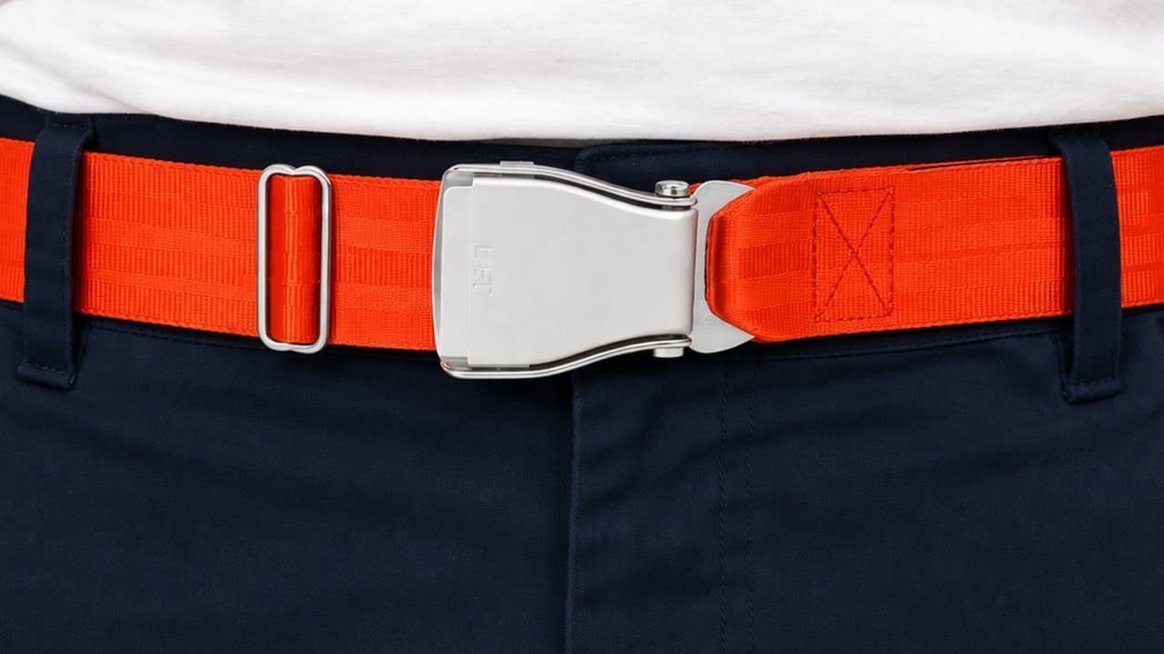 Signalorangefarbener TROPIC-Flugzeug-Gürtel an marineblauen Chinos mit weißem T-Shirt