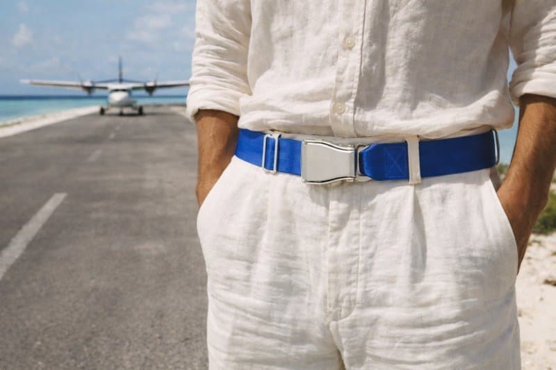 Elektrisch blauer PACIFIC-Flugzeug-Gürtel an weißer Leinenhose mit Leinenhemd