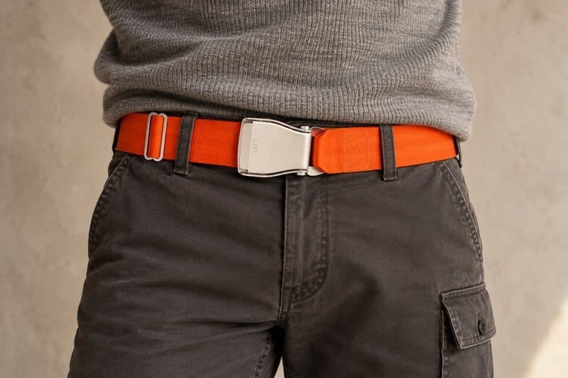 Signalorangefarbener TROPIC-Flugzeug-Gürtel an anthrazitfarbener Cargohose mit grauem Pullover